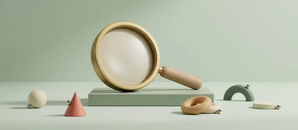 Lupa de latón apoyada sobre un pedestal bajo, entre formas geométricas de arcilla
