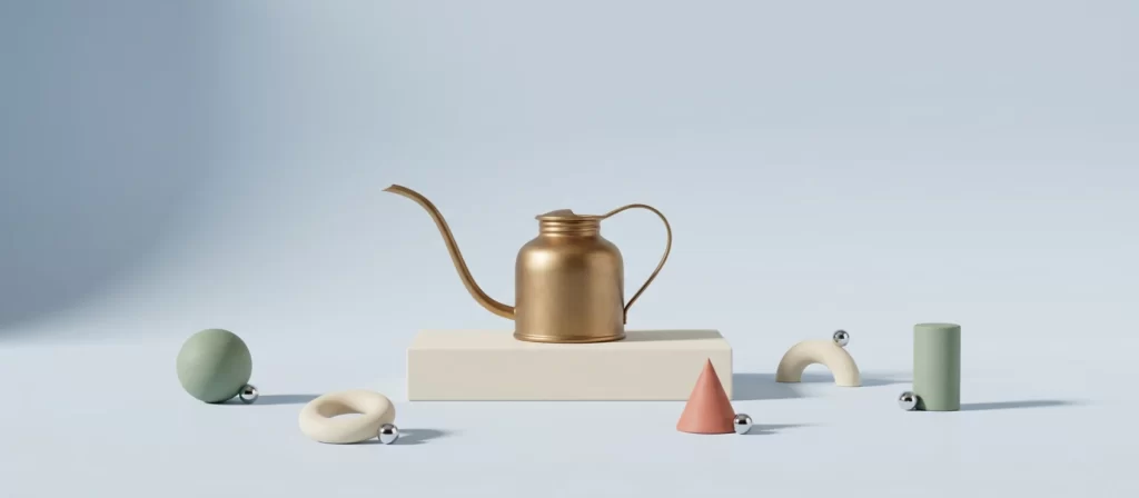 Aceitera de latón mate sobre un pedestal, rodeada de formas geométricas de arcilla en tonos pastel